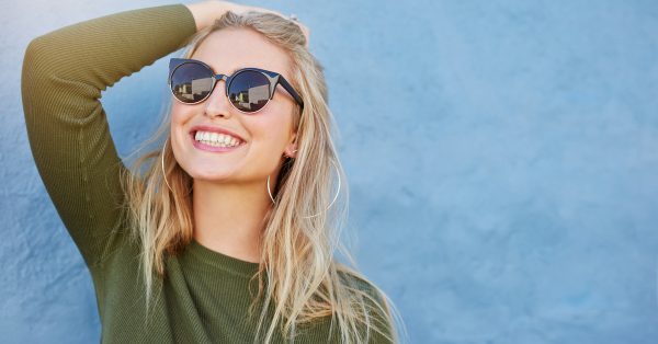 a woman smiles bright because her invisalign process worked wonders